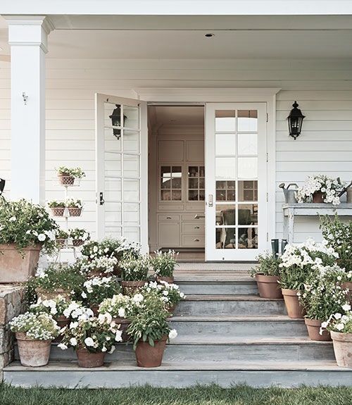 One flower pot would become insignificant on a wide porch. Massing pots together work with the scale of the home giving major curb appeal with minimal investment.